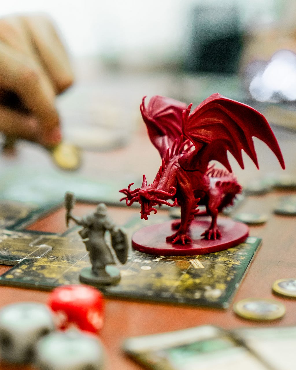 Um boneco de guerreiro e um boneco de um dragão em cima de um tabuleiro, simulando um jogo de rpg
