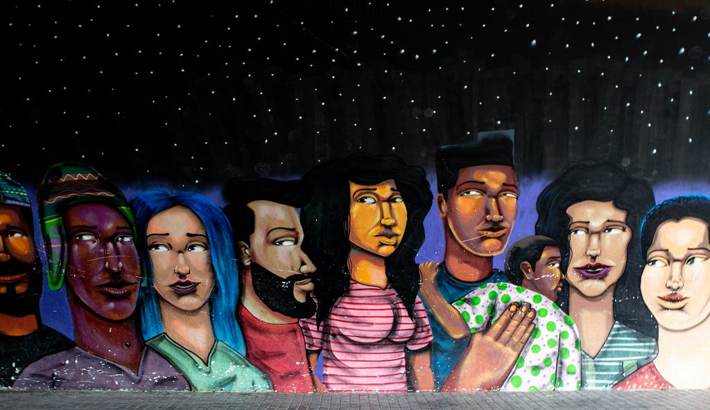 A photo of a wall mural of 7 cartoon people with varying skin colors.
