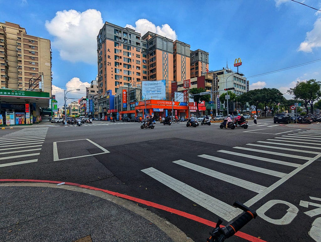 An ordinary crossroad. The image shows the normal daily life of Taiwanese and their scooters.