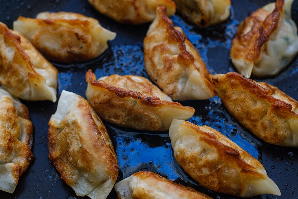 Korean dumplings (mandu) sizzling in a frying pan