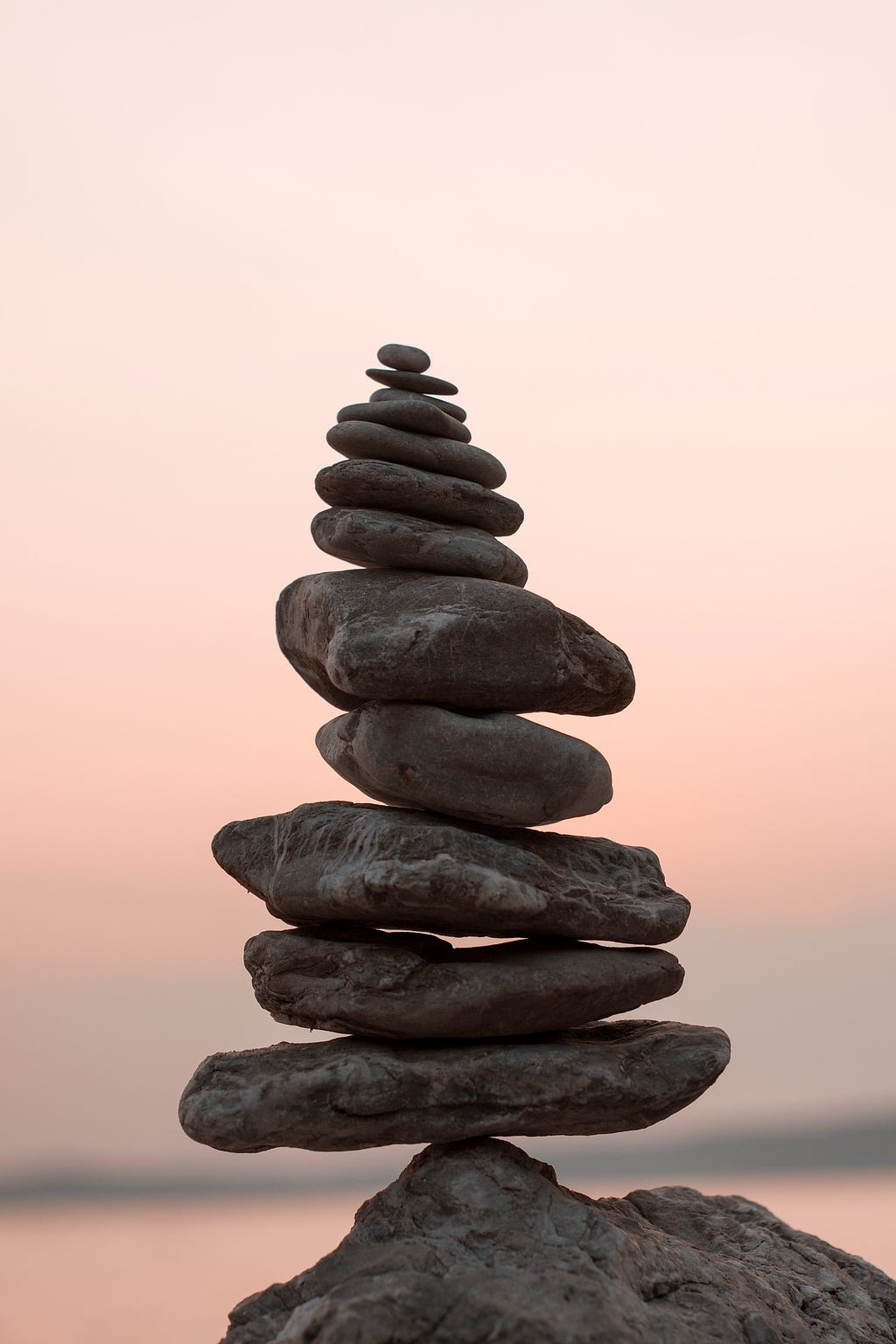 A pile of perfectly balanced rocks stands against the sky.
