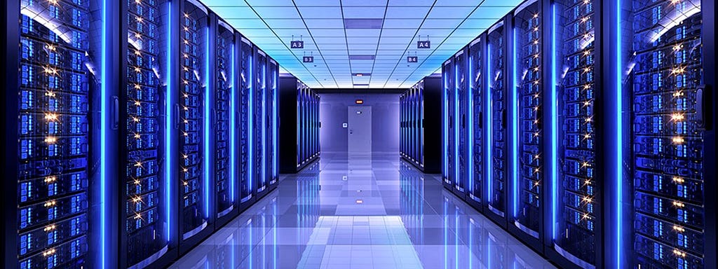 Corredor em uma Sala de Data center com servidores nos dois lados da sala iluminados com luzes azuis parecendo neon