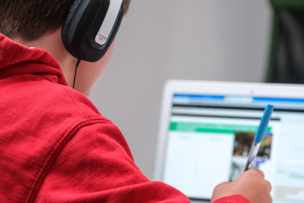 man working on a laptop wearing headphones