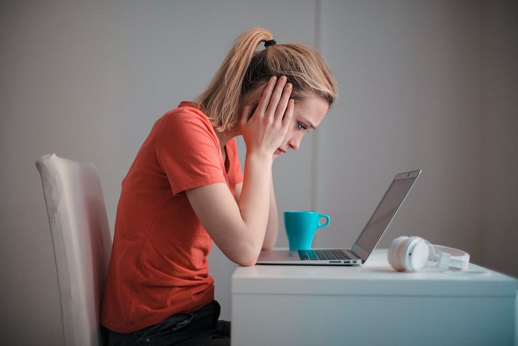 A girl reading a bad news on her laptop.