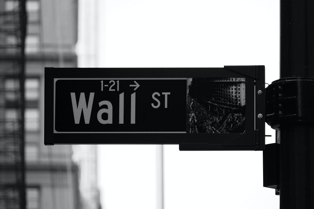 Photo of a “Wall St” street sign between 1 and 21 street