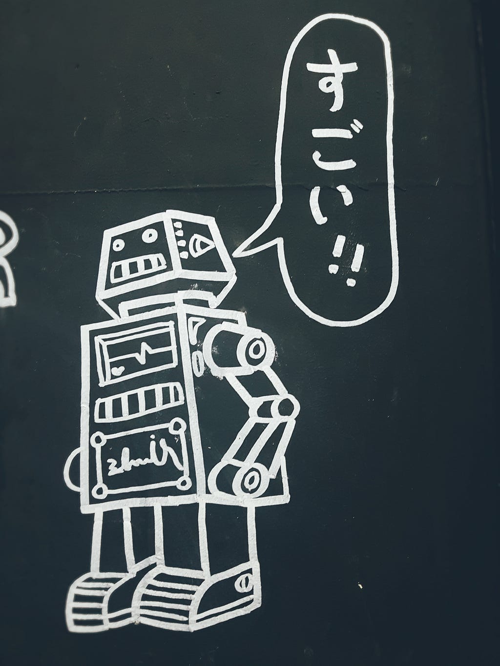 robot drawing on chalkboard saying the Japanese word ‘sugoi’