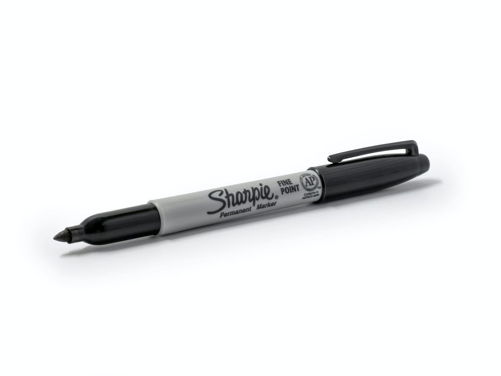 A photo of a sharpie permanent marker with a white background