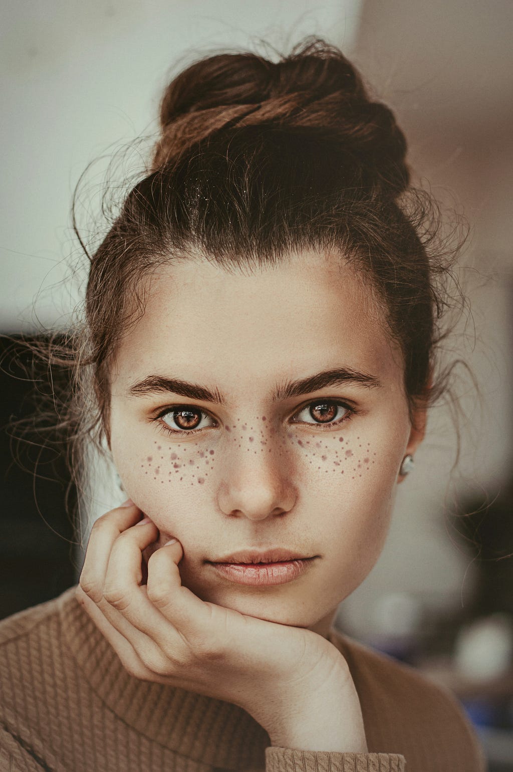 A woman’s face, freckles, hair up