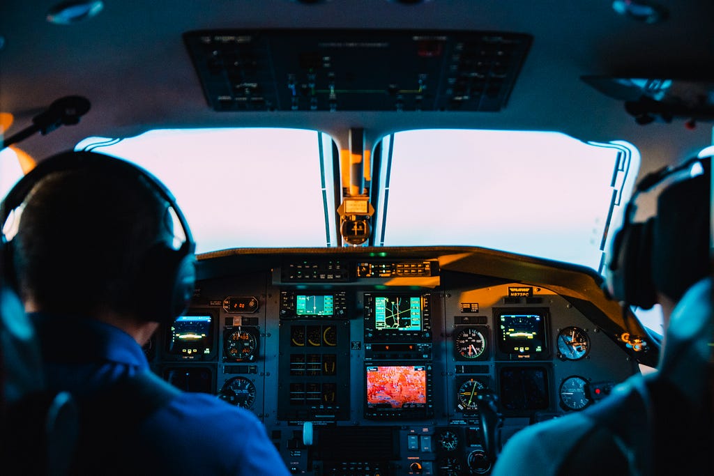 Two pilots in the cockpit of a jet airplane.