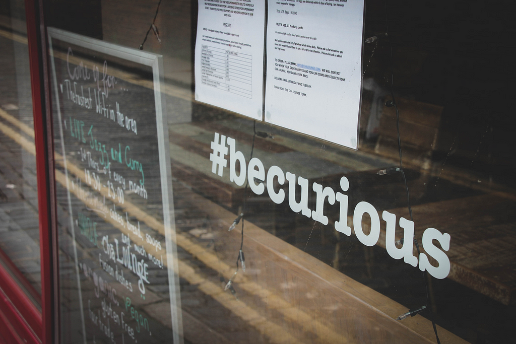 Be curious hashtag is reflected from a store window