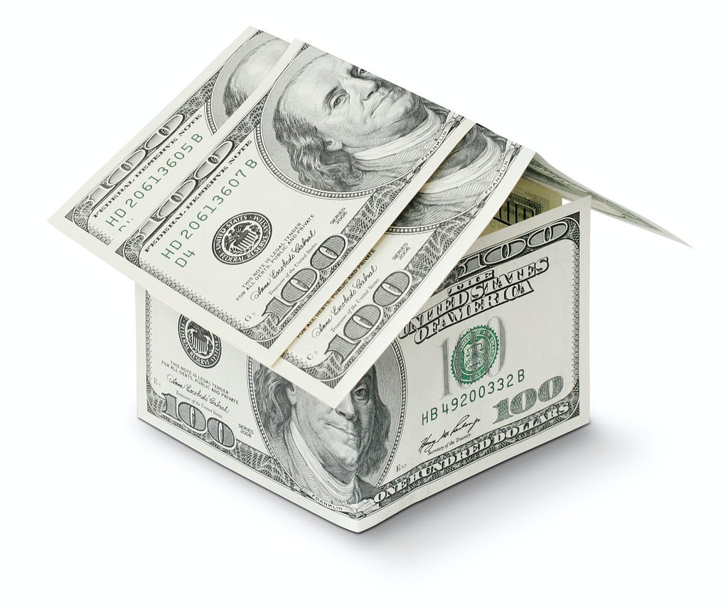 Several 100-dollar bills folded in the shape of a house