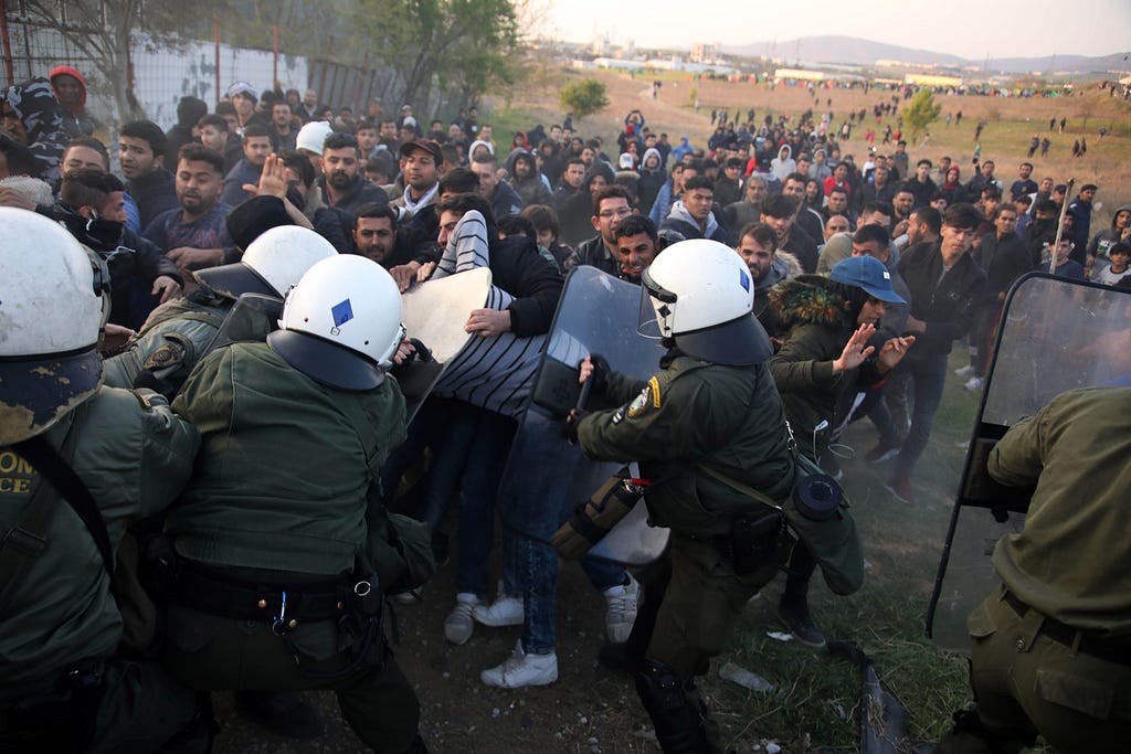 La policía antidisturbios griega se enfrenta a los inmigrantes en el exterior de un campo de refugiados en Diavata, un suburbio occidental de Salónica, el 4 de abril de 2019. (Sakis Mitrolidis / AFP vía Getty Images)