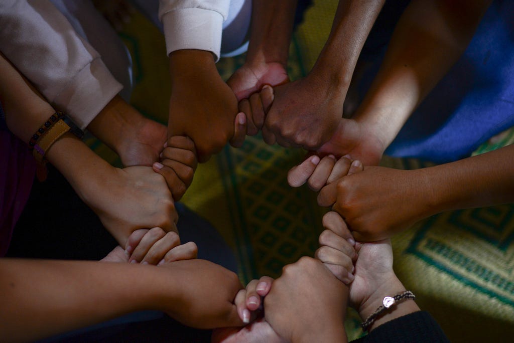 Multiple hands holding each other.