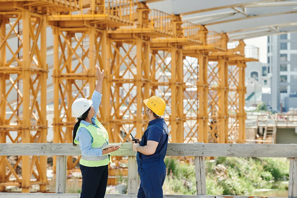 Construction manager observing job site with colleague