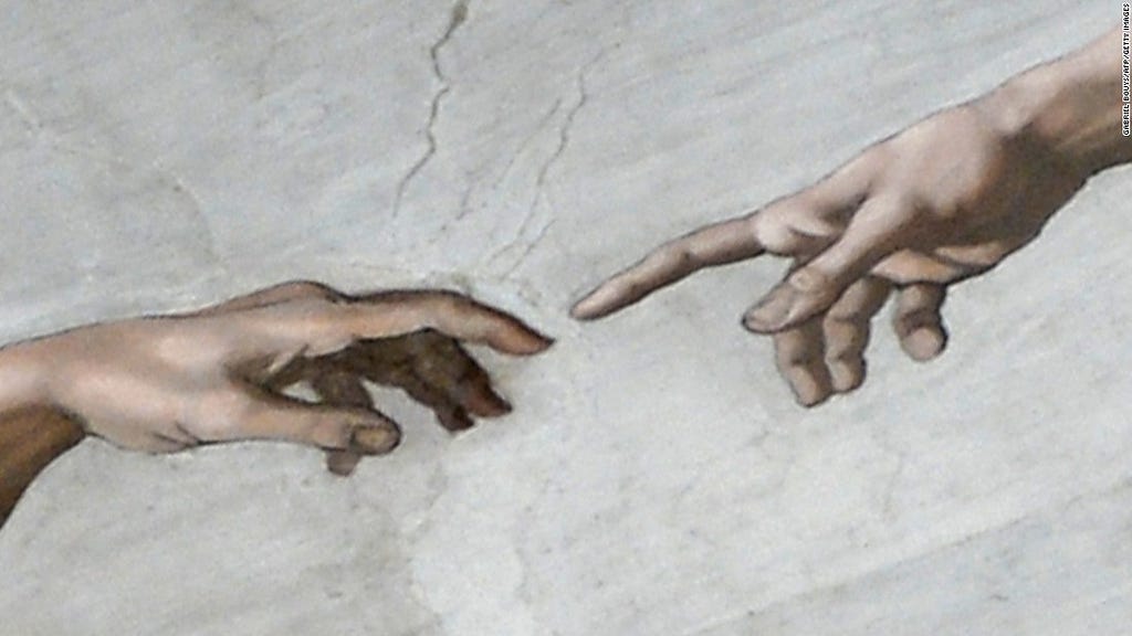 The hand of Adam and God in Michelangelo’s Creation of Adam.