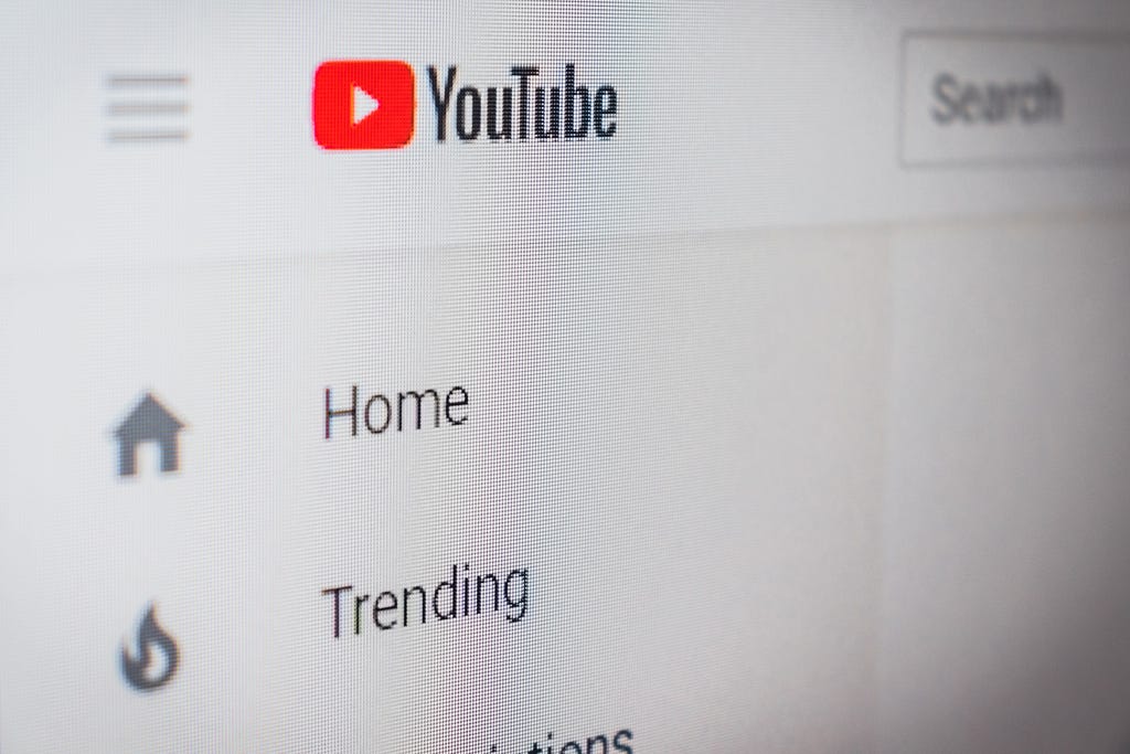 YouTube screenshot, with the logo (a white play button on a red curved square) beside “YouTube” in the center-top of the image