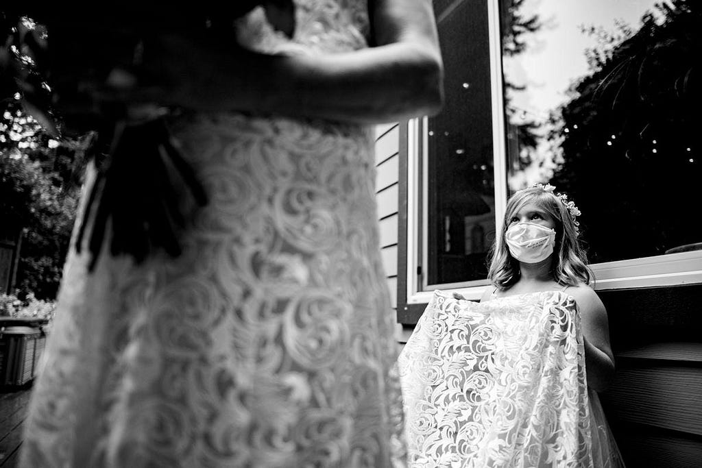 A child holds a bride’s dress.