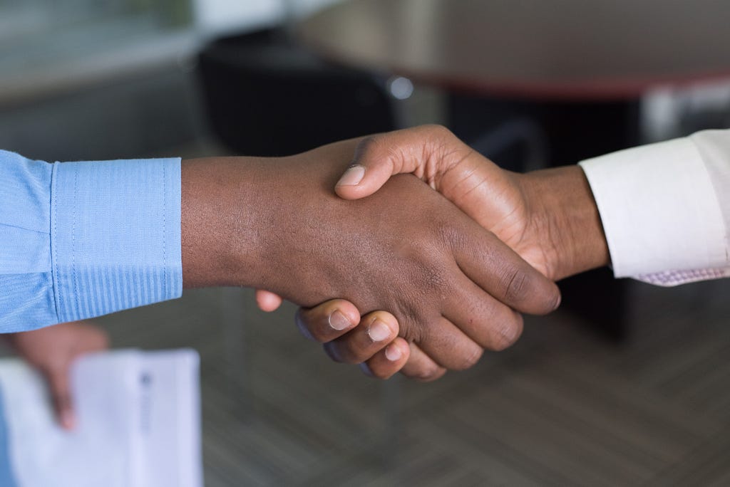 A handshake between two people in professional attire.