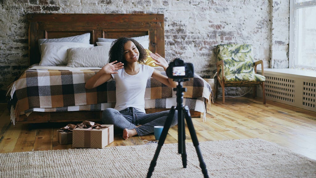 A female content creator making a YouTube video in her room