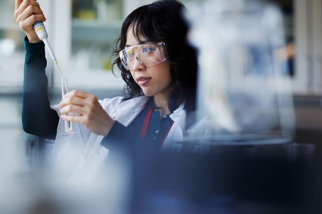 Female lab scientist pours liquid into tube — Invitae blog