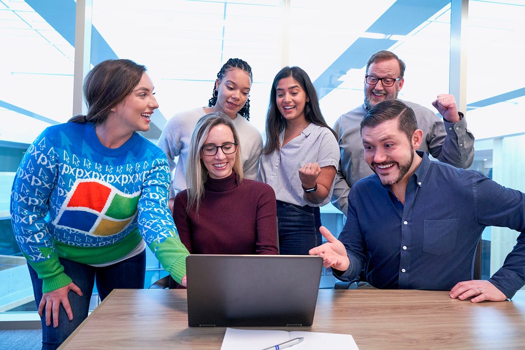 A group of people collaborating on project together and laughing