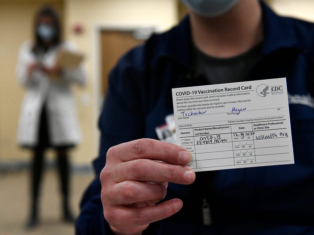 ICU nurse Megan Tschacher shows off her vaccination card at UC Health Poudre Valley Hospital in Fort Collins, Colorado.