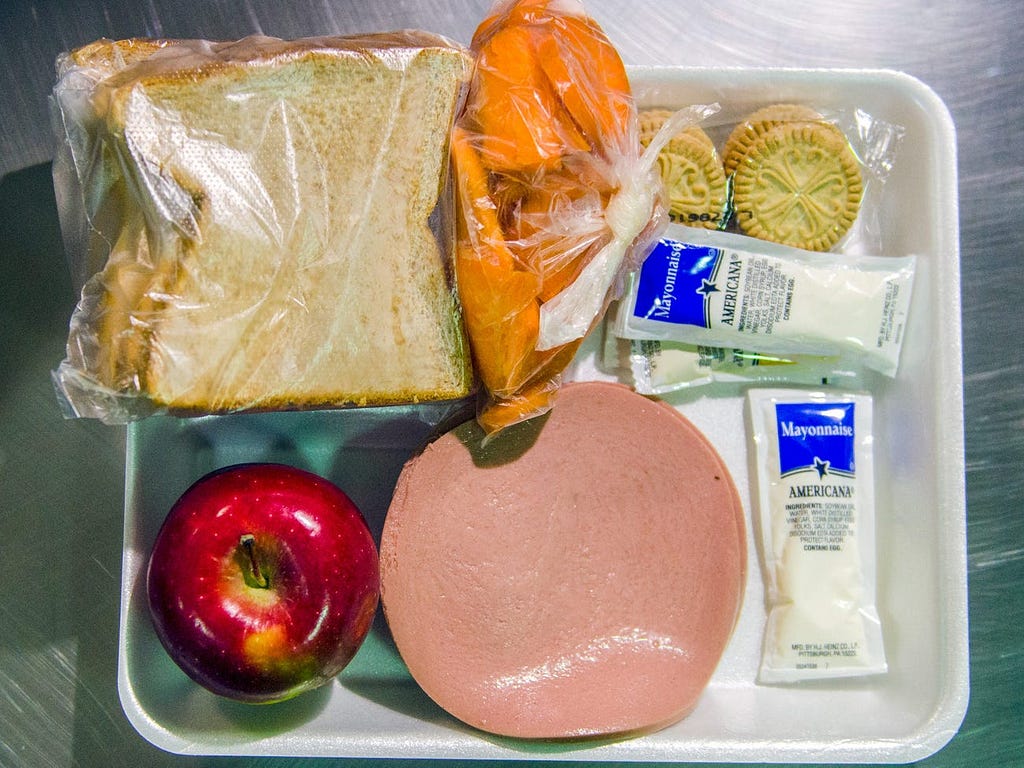 Bologna, two pieces of bread, mayonnaise, an apple, carrots, and crackers at the Theo Lacy Facility in Orange, California.