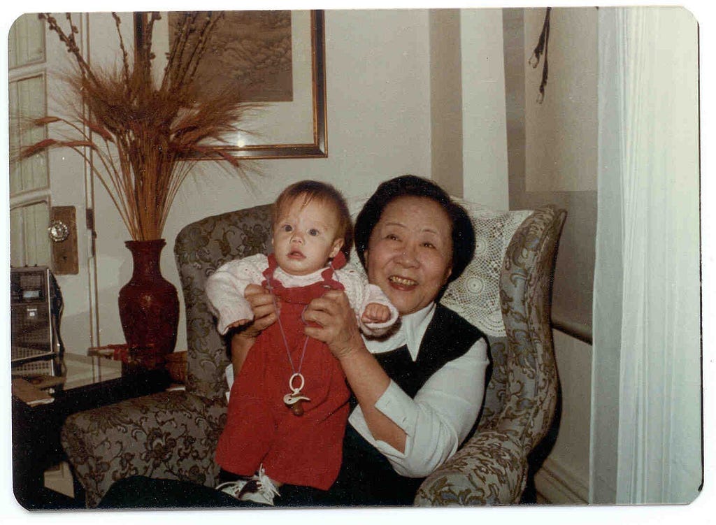 An in-color photo of Chien-Shiung Wu holding up her grandchild to the camera.