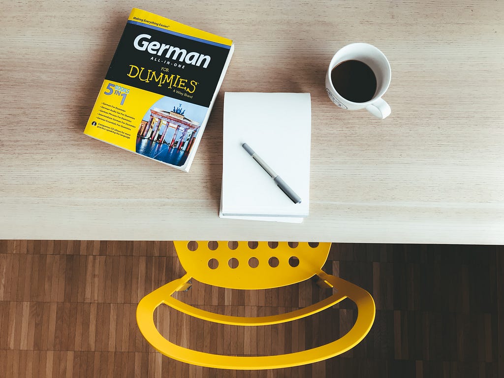 table and chair showing someone about to study with a german for dummies guidebook.