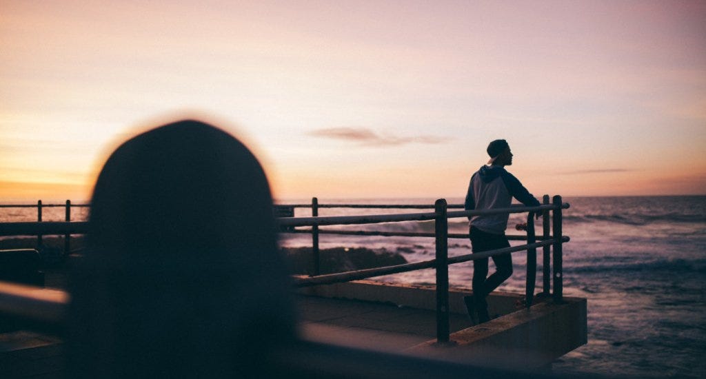 An entrepreneur looks out at sea during a sunset