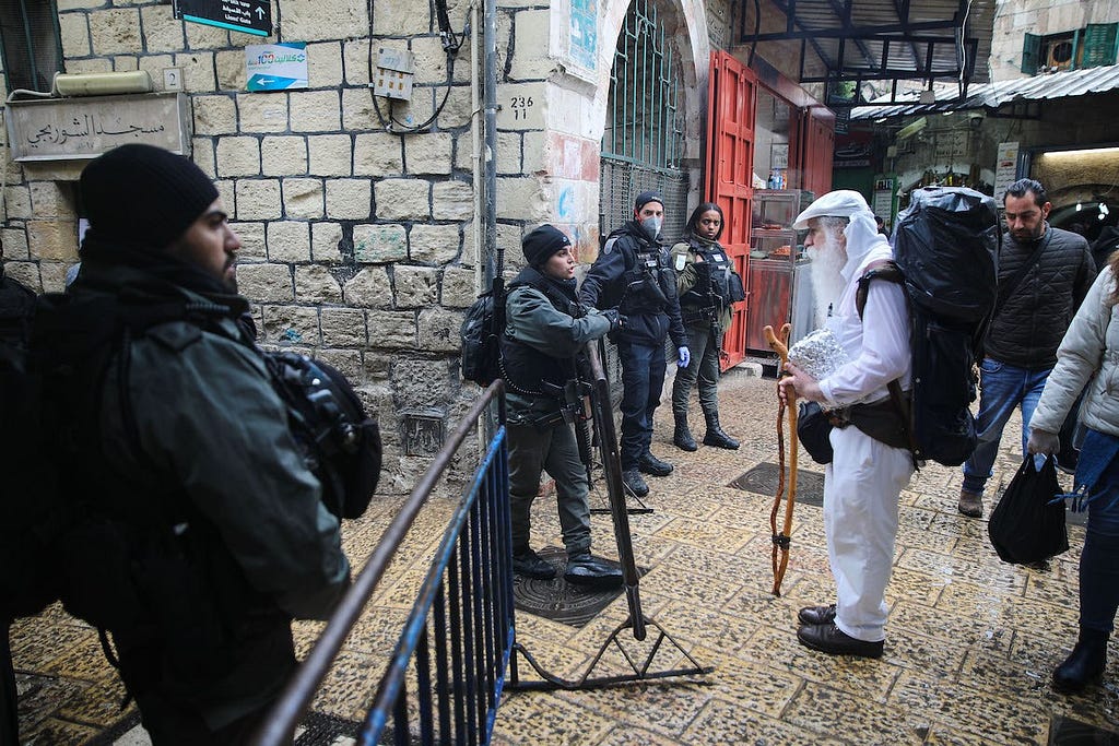 Fuerzas israelíes hacen guardia en un puesto de control, en el marco de las medidas adoptadas para frenar la pandemia del coronavirus (Covid-19), antes de la oración del Viernes en Jerusalén el 20 de marzo de 2020. (Foto: Mustafá Aljaruf / Agencia Anadolu)