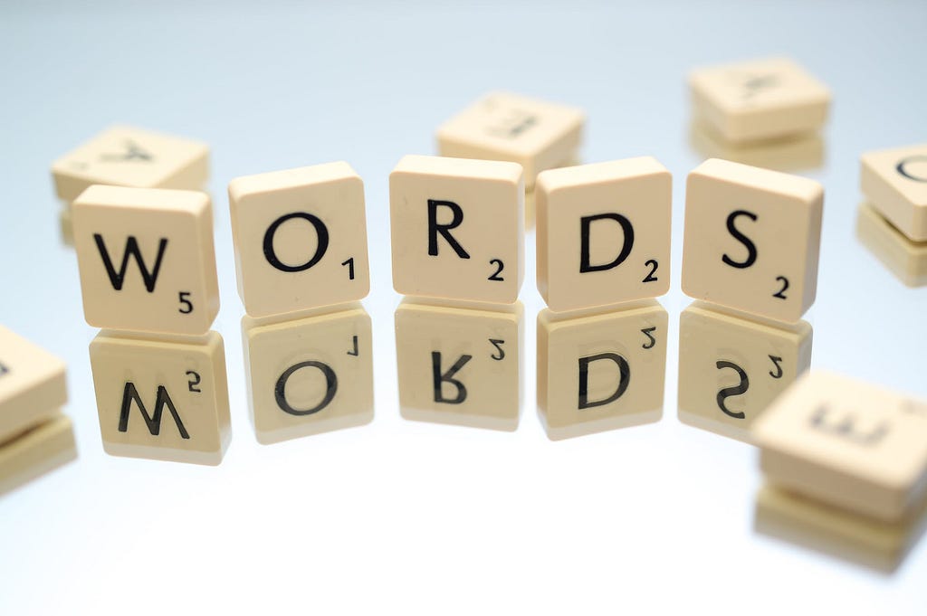 Letters from a game of scrabble arranged into the word ‘words’ on top a surface.