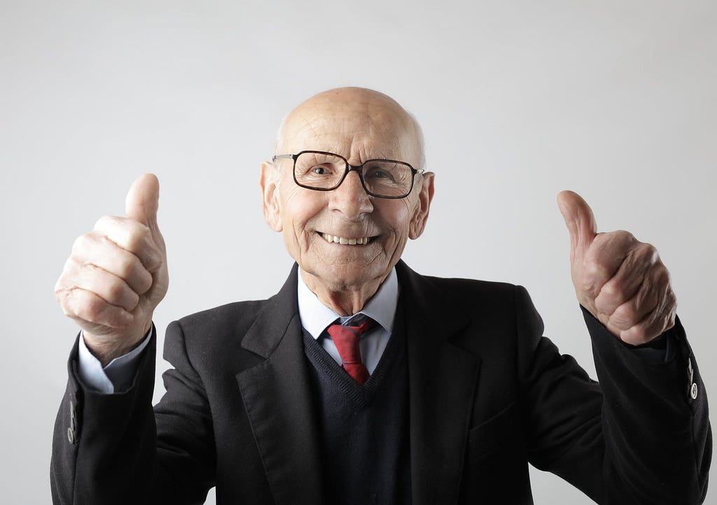 Old man holding a double thumbs up