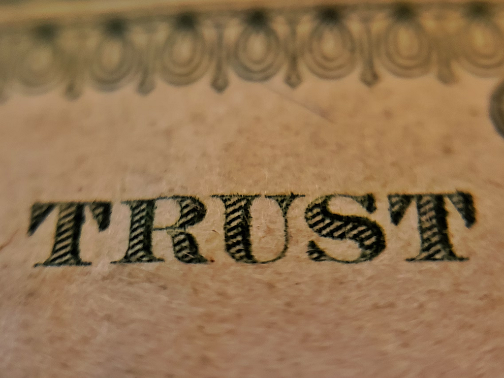 ‘Trust’ tattooed on skin. Photo by Joshua Hoehne on Unsplash