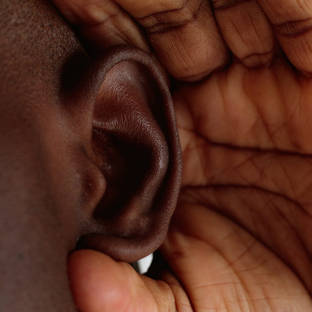 Close up of a man touching is ear.