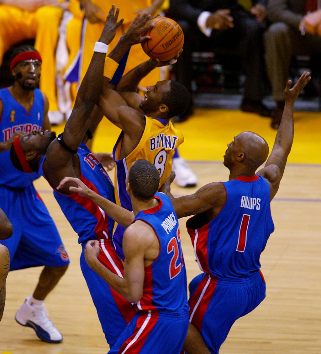 Kobe shooting the ball over several Detroit Pistons players