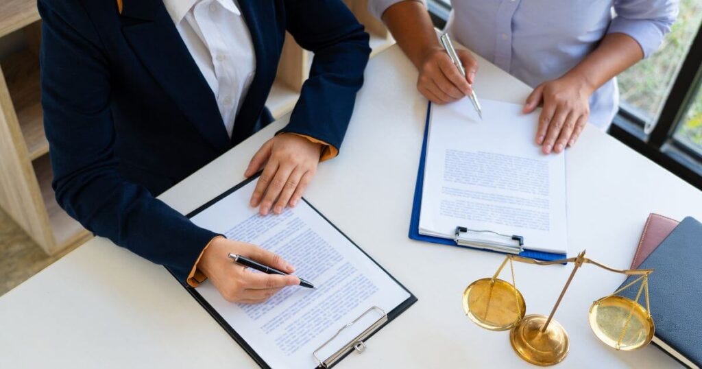 Two professionals reviewing legal documents, showing the collaboration between an estate executor and an estate planning lawyer to ensure the accurate execution of a will.