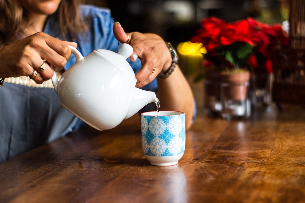 Woman making a cup of tea to soothing the heartburn