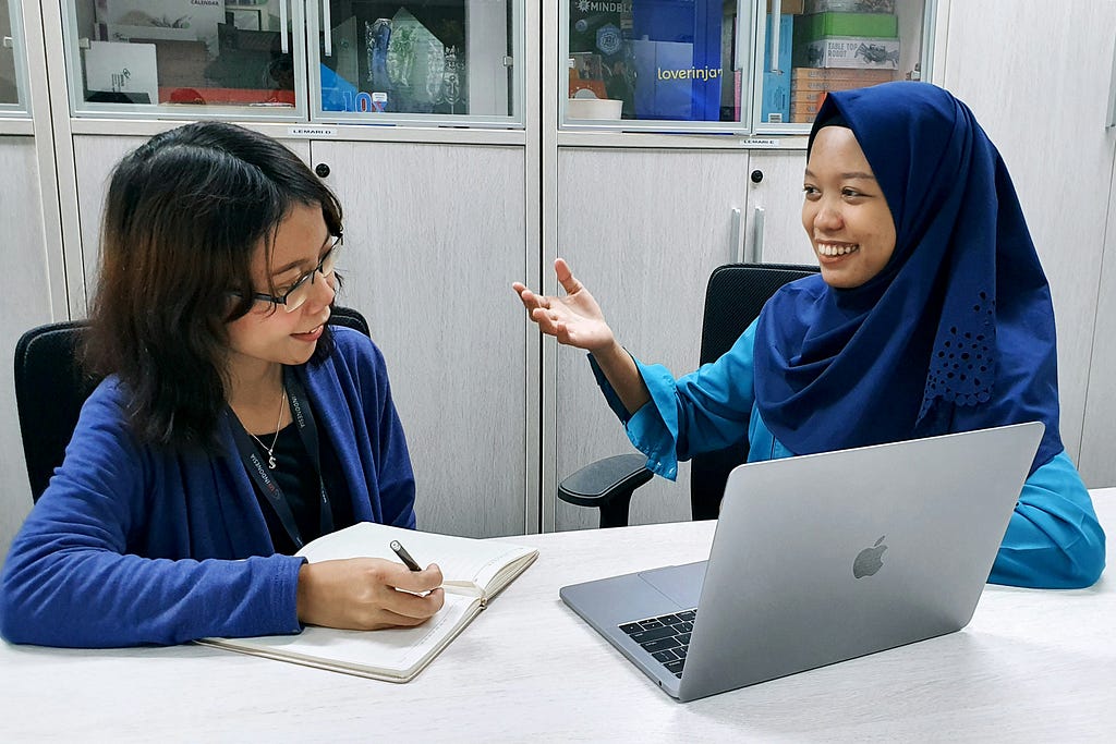 Two women carry out a usability test in an office.