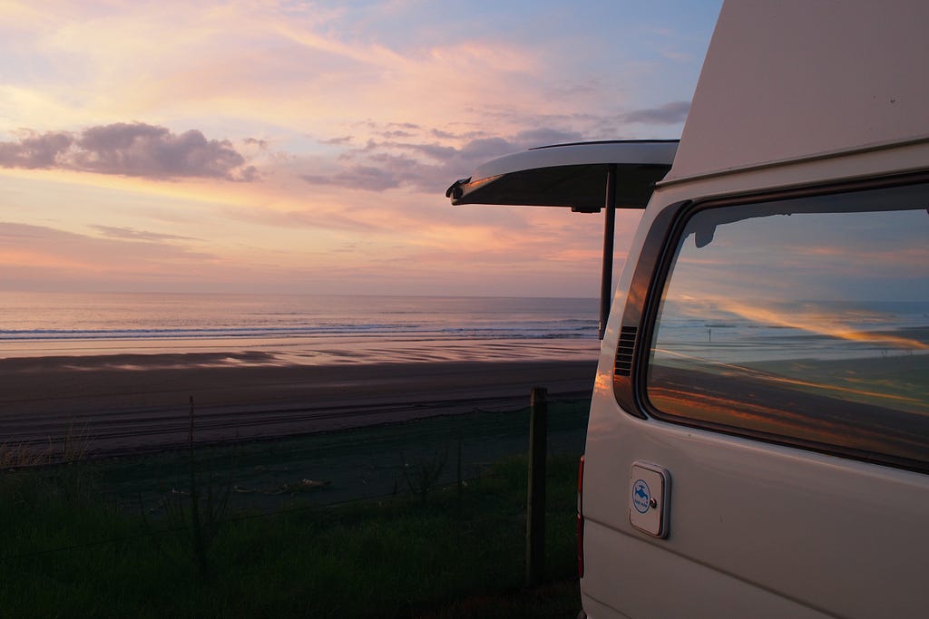 Campervan on beach in sunset