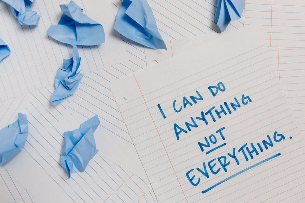 A written productivity motivational quotes using blue marker and crumpled papers.