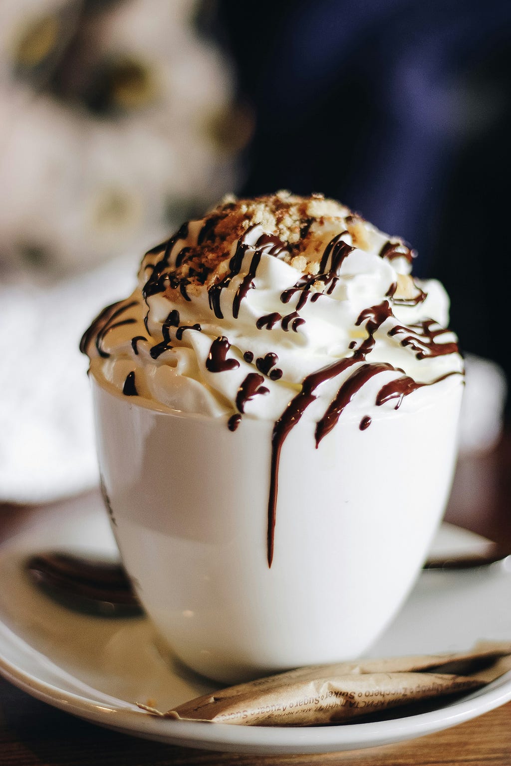 hot chocolate drink with whipped cream, drizzle chocolate and nuts