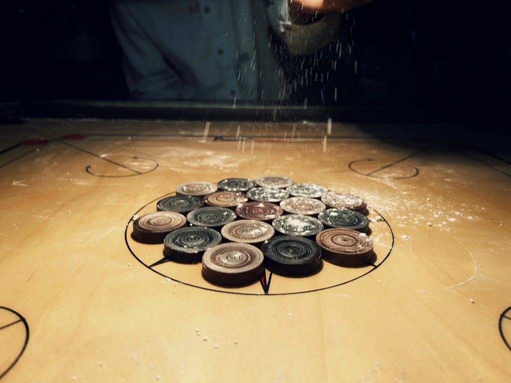 Player sprinkles powder on the carrom board