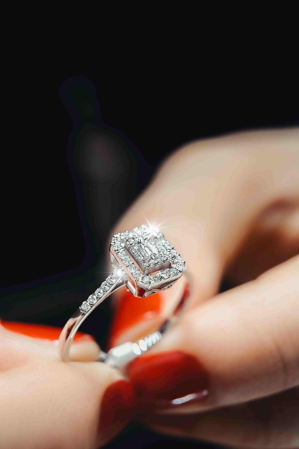 A woman holding a diamond engagement ring