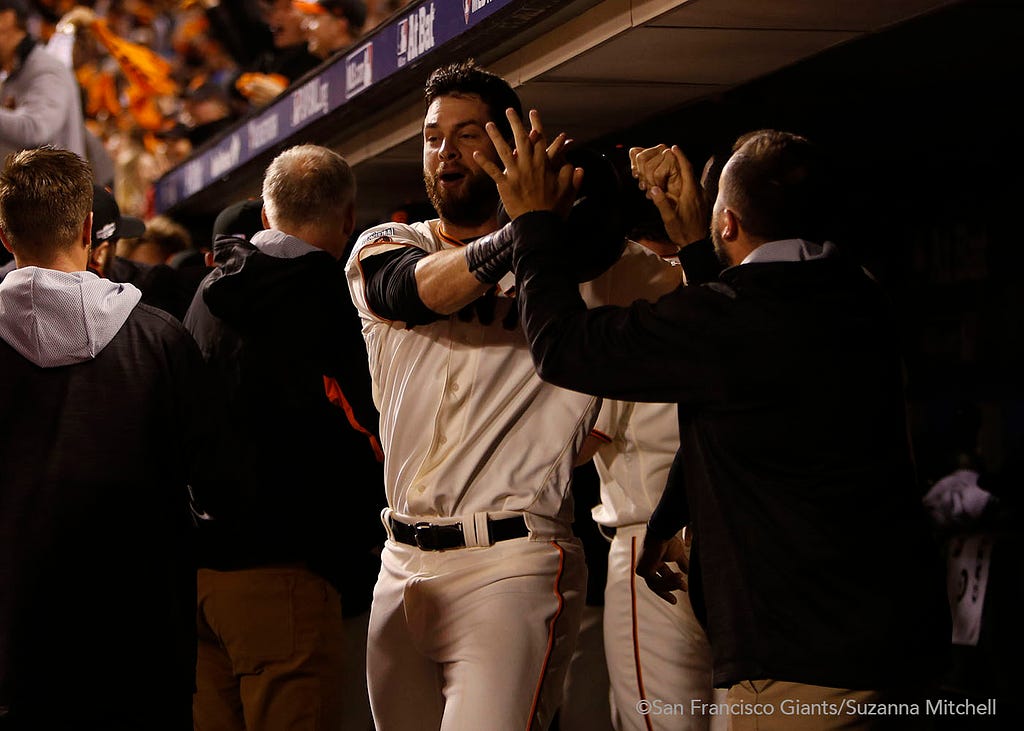 Brandon Belt celebrates after scoring on a triple hit by Conor Gillaspie in the eighth inning.