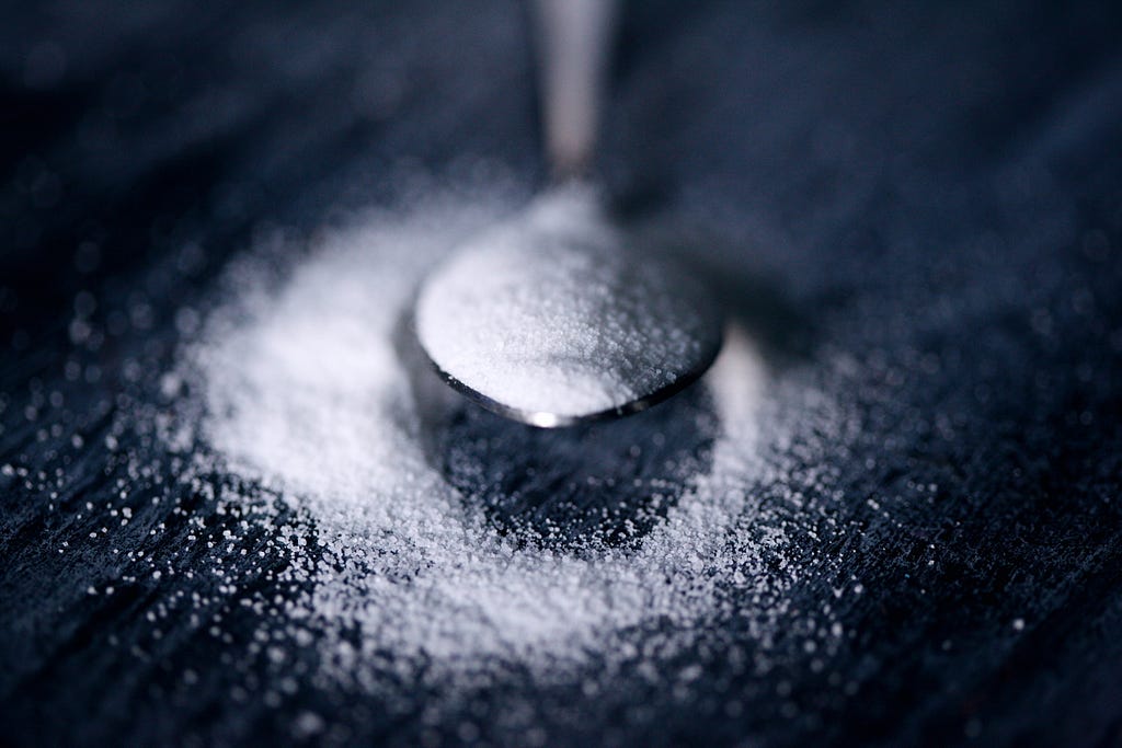 sugar pouring into a spoon