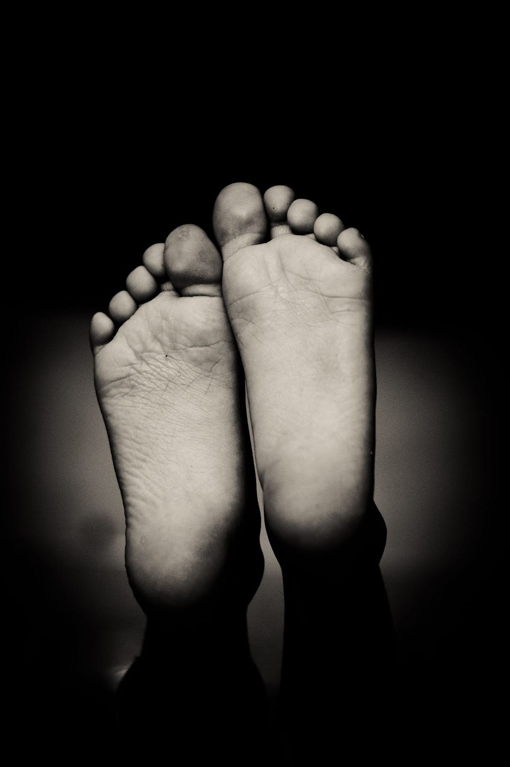 A black and white image of feet soles.