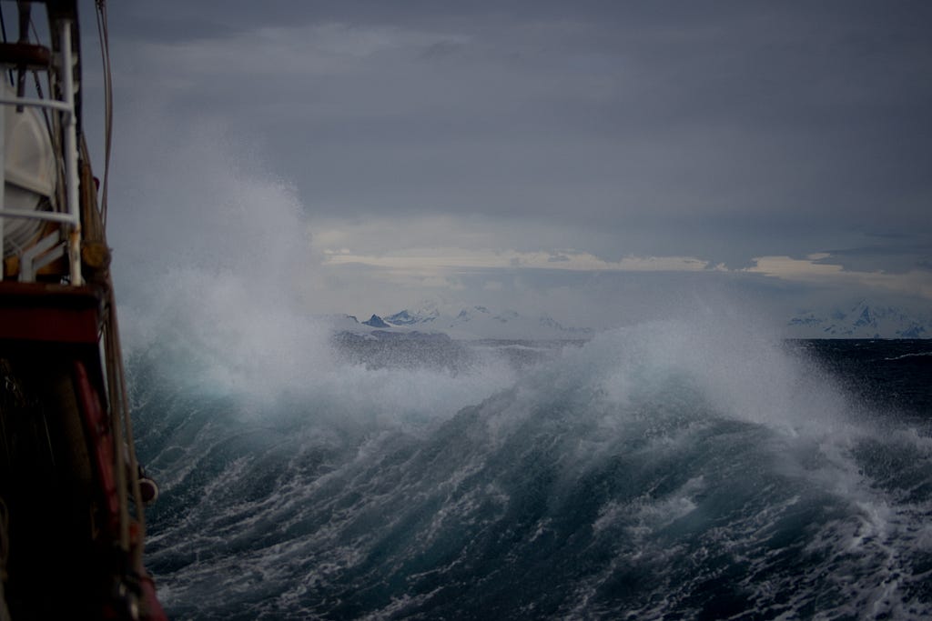 Waves crashing in a stormy, dark sky.