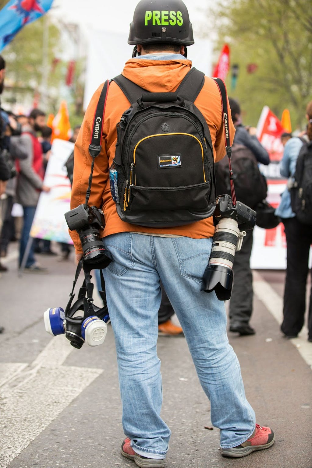 A press reporter facing a crowd of protestors.