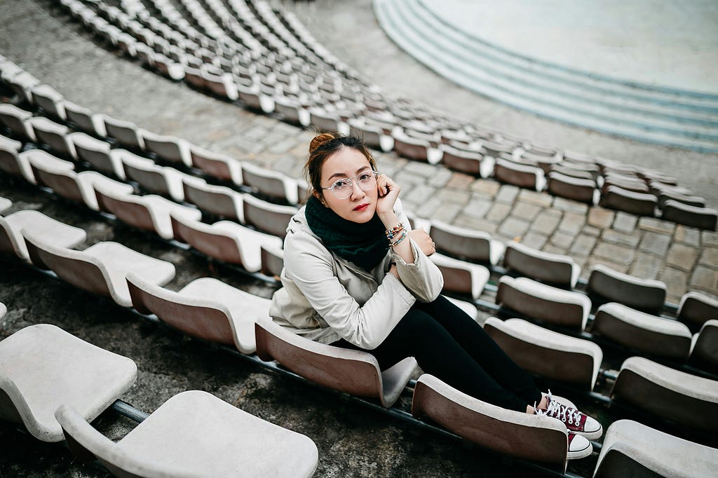 A lady seated on a stadium chair